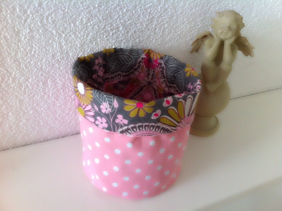 Rosa Stoffkorb mit weißen Punkten und floral gemustertem Innenfutter