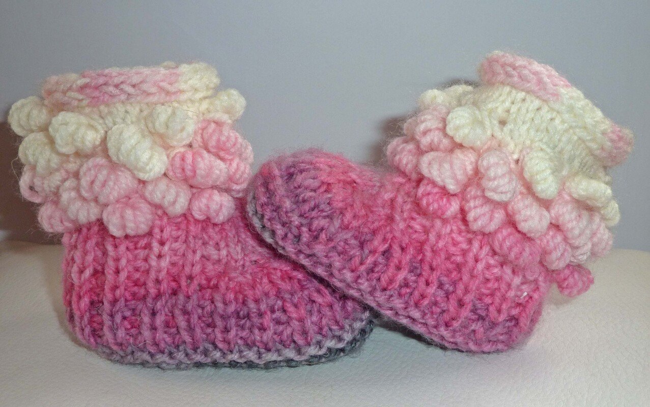 rosa gestrickte Babyschuhe mit geripptem Fuß und Noppenbündchen