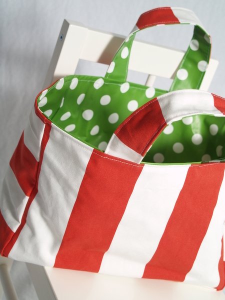 Einkaufstasche mit roten und weißen Streifen und grünem Innenfutter mit weißen Punkten