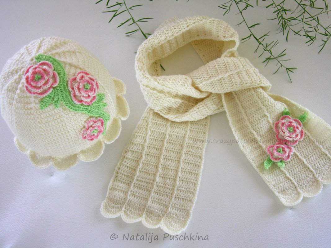 Cremefarbenes gehäkeltes Mützen- und Schal-Set mit rosa Rosenapplikationen und grünen Blättern