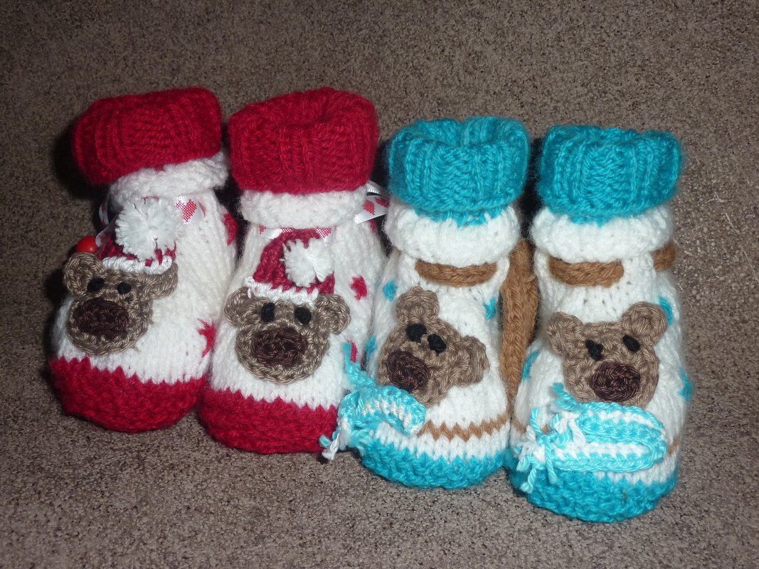 Zwei Paare Babyschuhe mit Teddybär-Applikationen, eines rot-weiß, eines türkis-weiß