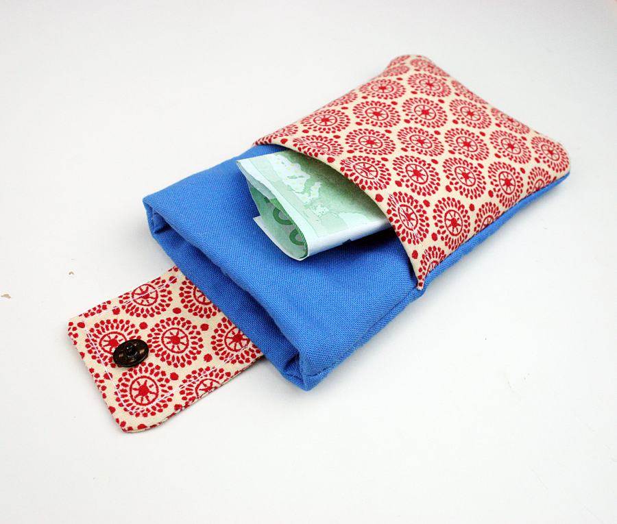 Kleines blaues Täschchen mit rot-beiger gemusterter Klappe und Knopf