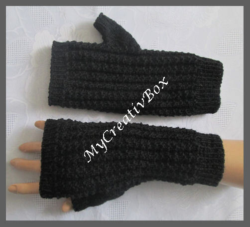 Schwarze, gestrickte Armstulpen mit Daumenöffnung, einer getragen, einer flach liegend.