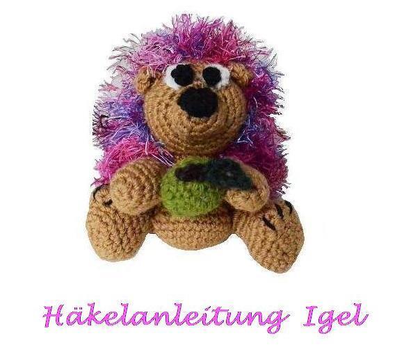Gehäkelter Amigurumi-Igel mit pink-lila Flausch und sichtbarem Schriftzug 'Häkelanleitung Igel'