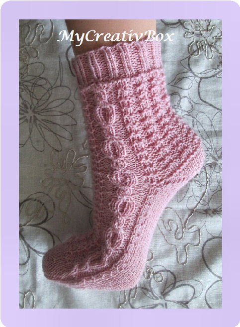 Rosa gestrickte Socke mit seitlichem Zopfmuster, geripptem Bündchen und feiner Maschenstruktur