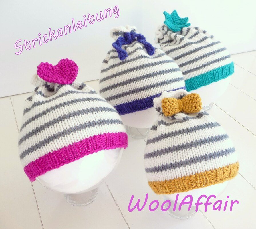 Vier gestrickte Babymützen grau-weiß gestreift mit bunten Bündchen und Applikationen wie Herz, Schleife und Krone