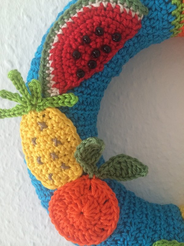 Blauer gehäkelter Kranz mit gehäkelten Früchten: Wassermelonenscheibe, Ananas und Orange