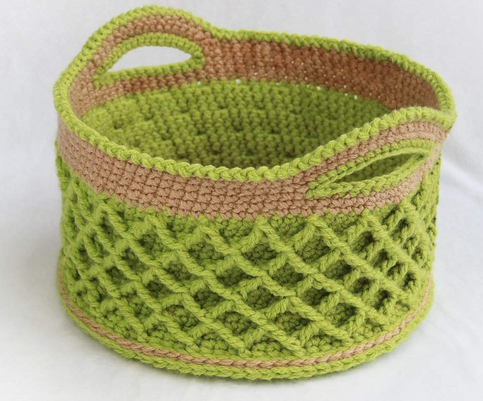Round green crocheted basket with beige rim, diamond lattice stitch and integrated handles.