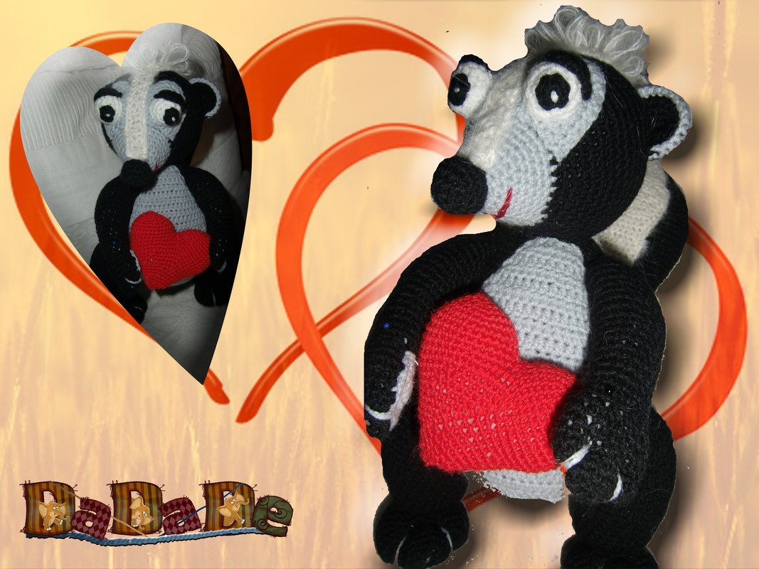 Gehäkeltes Amigurumi-Stinktier in Schwarz, Weiß und Grau hält ein rotes Herz.