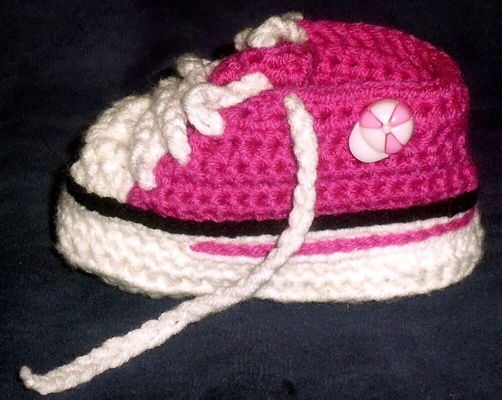 Rosa-weißer gehäkelter Babyschuh im Sneaker‑Stil mit Kordel und seitlichem Knopf