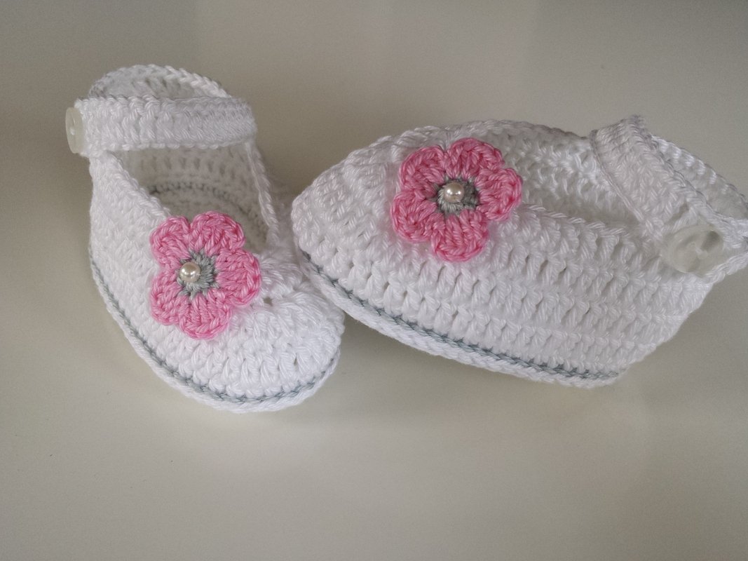 Weiße handgehäkelte Baby-Ballerinas mit rosa Blüten und Perlen