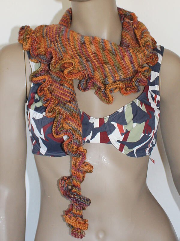 Nahaufnahme eines mehrfarbigen, gestrickten Tuchs mit Rüschensaum an einem Mannequin