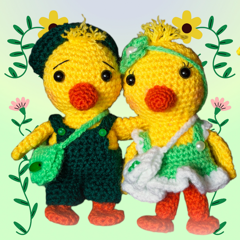 Zwei gehäkelte gelbe Küken-Amigurumi mit grüner Kleidung, Taschen und orangefarbenen Schnäbeln