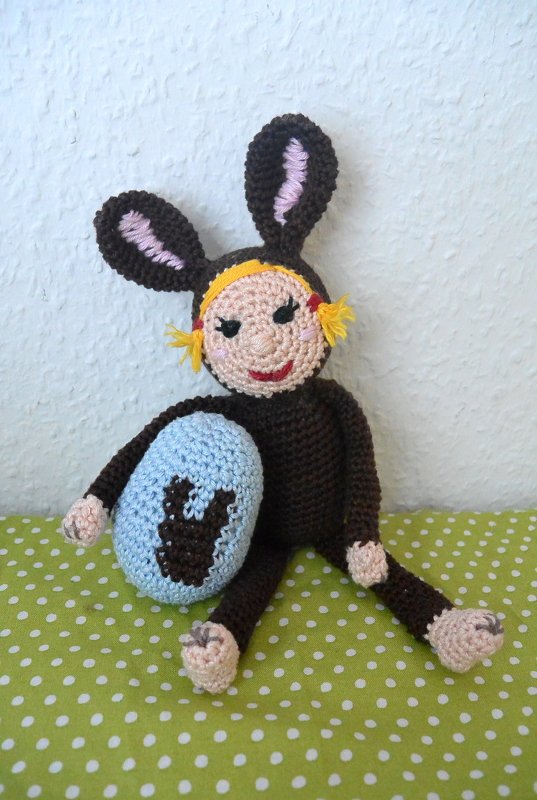 Gehäkelte Puppe im braunen Hasenkostüm mit hellblauem Osterei
