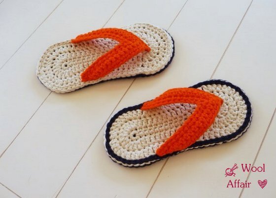 Gehäkelte Flip‑Flop‑Hausschuhe mit beiger Sohle, dunkler Kante und orangefarbenem Riemen