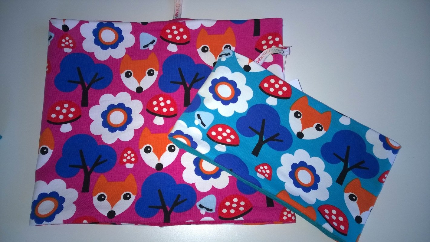 Zwei genähte Hüllen mit buntem Fuchs- und Blumenmuster in Pink und Türkis.