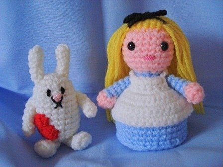 Blau-weiße gehäkelte Amigurumi-Puppe neben kleinem weißen Hasen mit rotem Herz