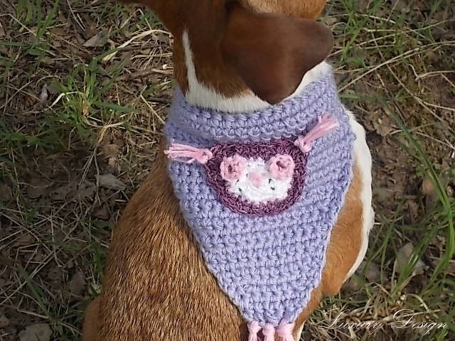 Brauner Hund mit gehäkeltem lila Halstuch mit rosa-weißer Blütenapplikation und Fransen