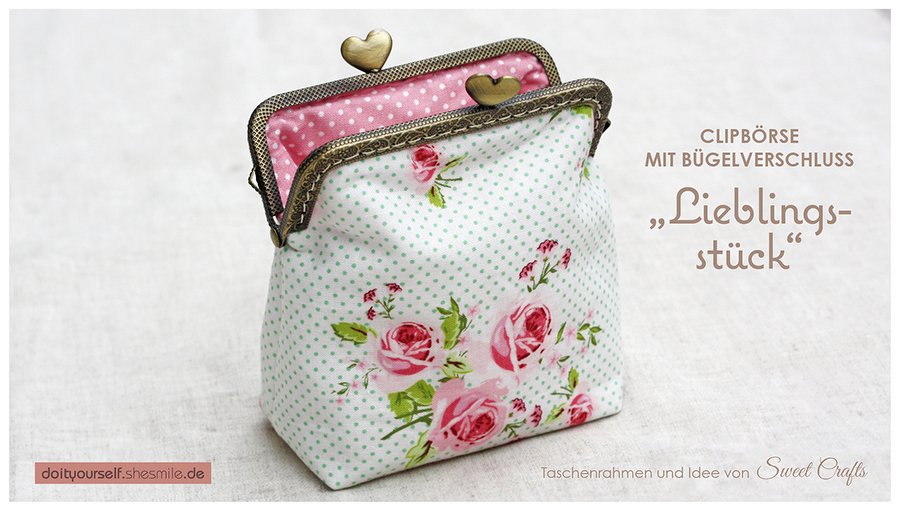 Offene Stoff-Clipbörse mit roten Rosen, grünem Punktmuster und rosafarbenem Innenfutter; Metallbügelverschluss mit herzförmigen Griffen.