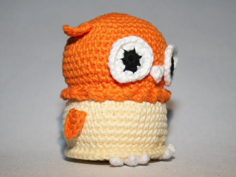 Gehäkelte Amigurumi-Eule orange oben creme unten mit weißen Augen