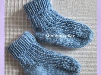 Paar blau gestrickter Babysocken mit Rippenbündchen und feinem Strukturmuster