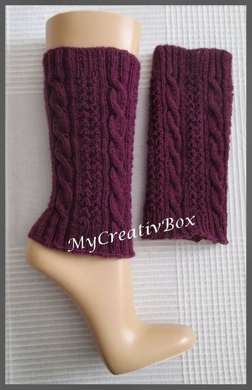 Dunkelviolette gestrickte Beinstulpen mit Zopfmuster auf einem Mannequinbein
