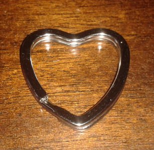 Herzförmiger Metall-Schlüsselring auf Holz