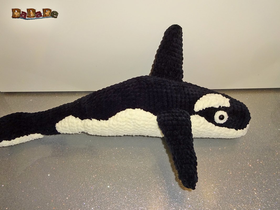 Gehäkelter schwarz-weißer Amigurumi-Orca liegend