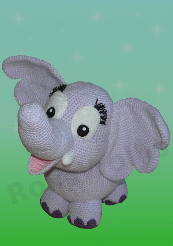 Lavendelfarbener gehäkelter Amigurumi Elefant mit großen Ohren vor grünem Hintergrund