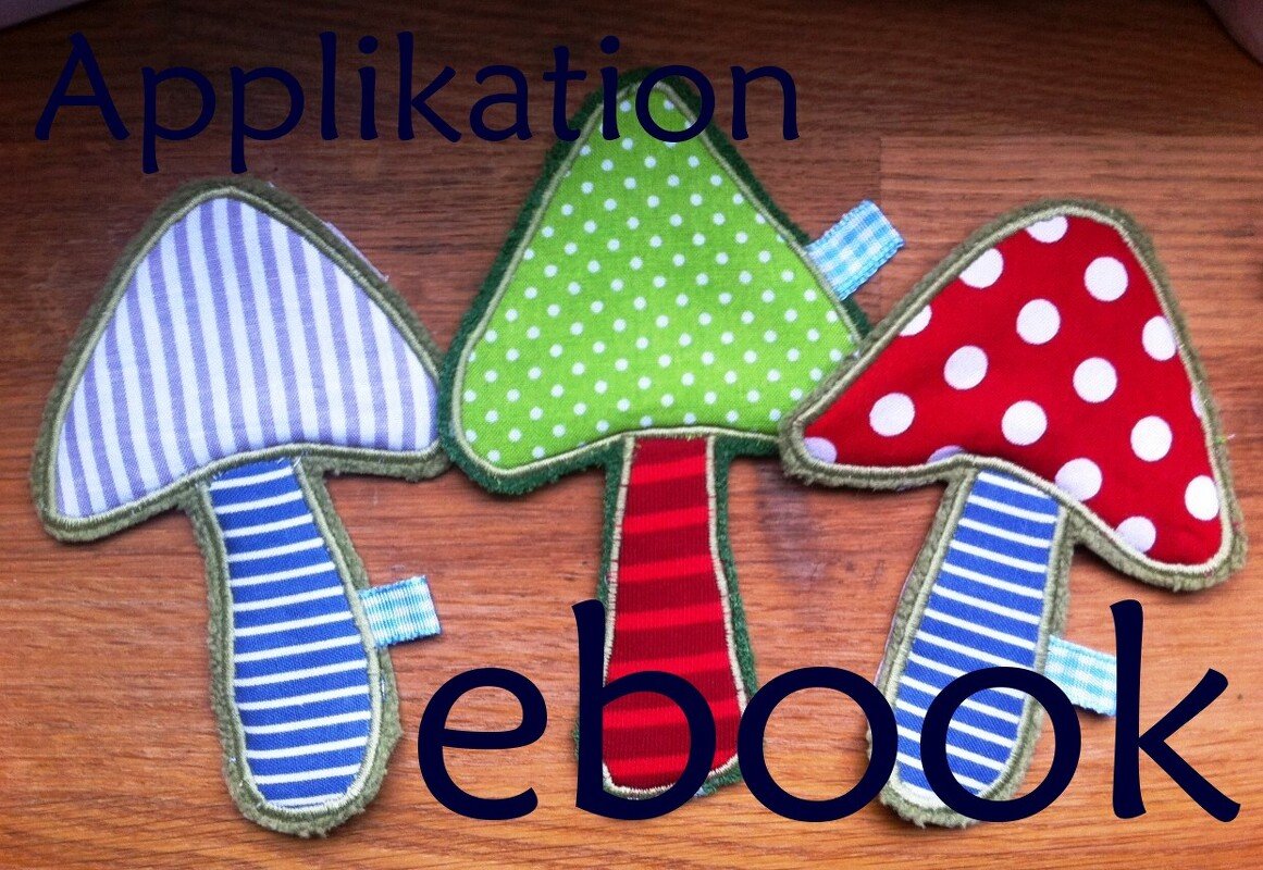 Drei Stoffapplikationen in Pilzform mit Punkten und Streifen auf Holz; Schriftzug „Applikation ebook“ sichtbar.