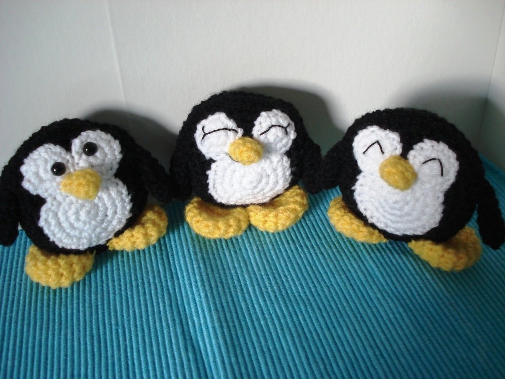 Drei gehäkelte Pinguine in Detailansicht mit Fokus auf Körperform, Füße und Augenvarianten