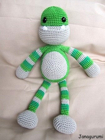 Gehäkeltes Amigurumi-Monster in Grün und Grau mit gestreiften Gliedmaßen und rundem Bauch