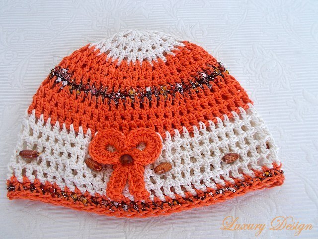 Gehäkelte Mütze in Orange und Weiß mit Schleife und Perlen