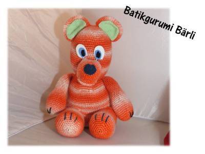Gehäkelter Amigurumi-Teddybär mit orange-weißen Streifen und grünen Innenohren