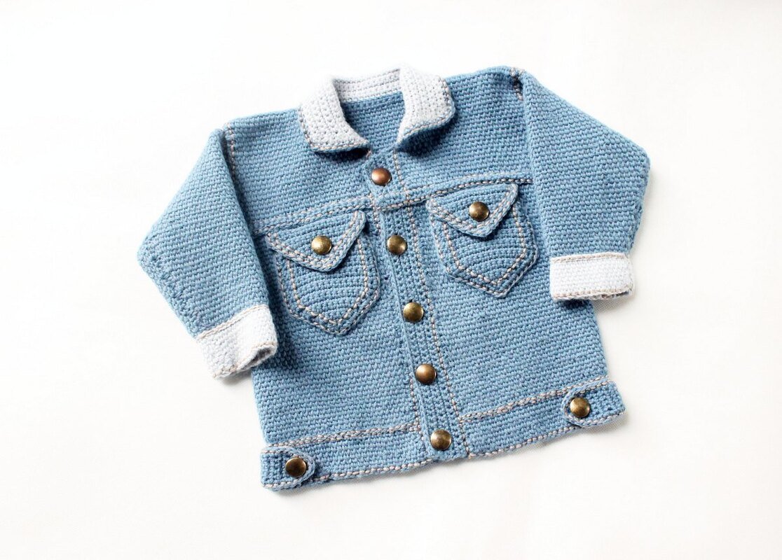 Light blue crocheted baby jacket with light grey collar and cuffs, flap pockets and round metal buttons