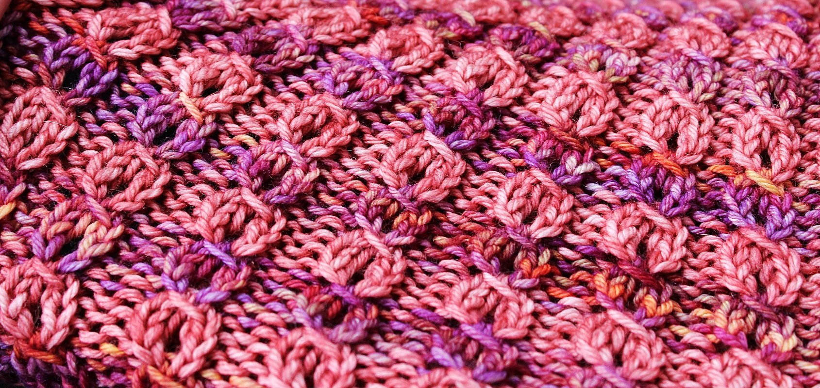 Nahaufnahme gestricktes Muster in Pink- und Violetttönen