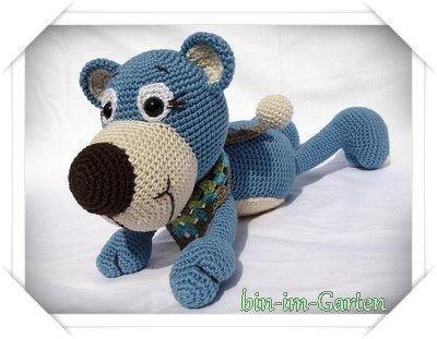 Blauer handgehäkelter Teddybär mit beiger Schnauze und gemustertem Halstuch