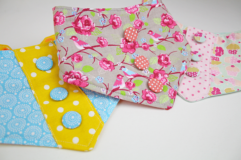 Drei Baby-Halstücher mit mehreren Druckknopf-Positionen zur Größeneinstellung aus verschiedenen gemusterten Stoffen