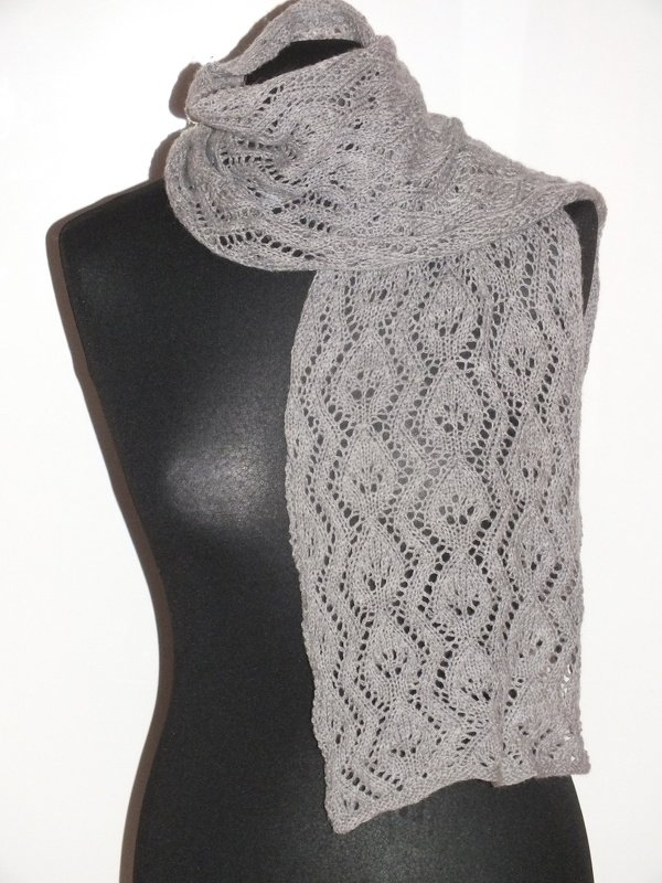 Grau gestrickter Schal mit feinem Blatt-Lochmuster auf schwarzer Schneiderpuppe