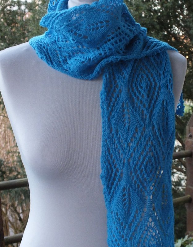 Blauer Strickschal mit Rauten‑Lochmuster auf weißer Schaufensterpuppe