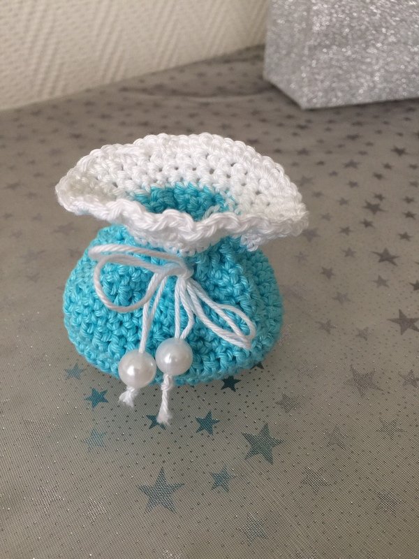 Hellblaues gehäkeltes Säckchen mit weißer Rüsche und Perlen am Kordelzug