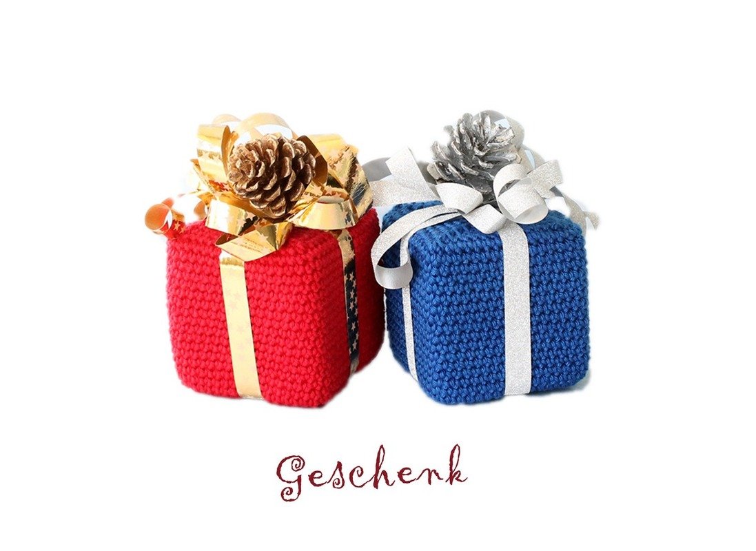 Gehäkelte Mini-Geschenkboxen in Rot und Blau mit Schleifen und Zapfen