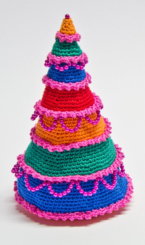 Gehäkelter, mehrfarbiger Weihnachtsbaum mit pinken Rüschen und Perlen