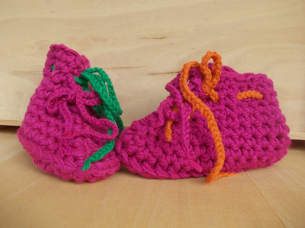 Pinke gehäkelte Babyschuhe mit orange-grünem Schnürband, Detailansicht