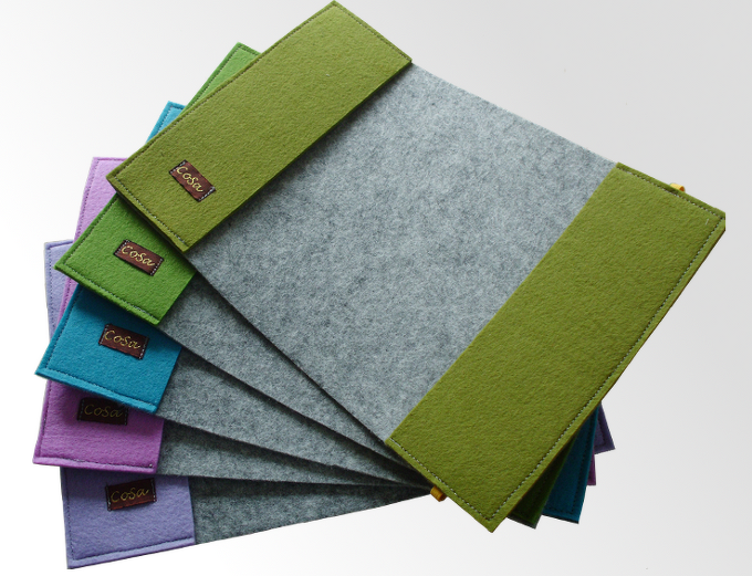 Fächerförmig angeordnete graue Filztaschen mit farbigen Seiten in Grün, Türkis, Violett und Lila.