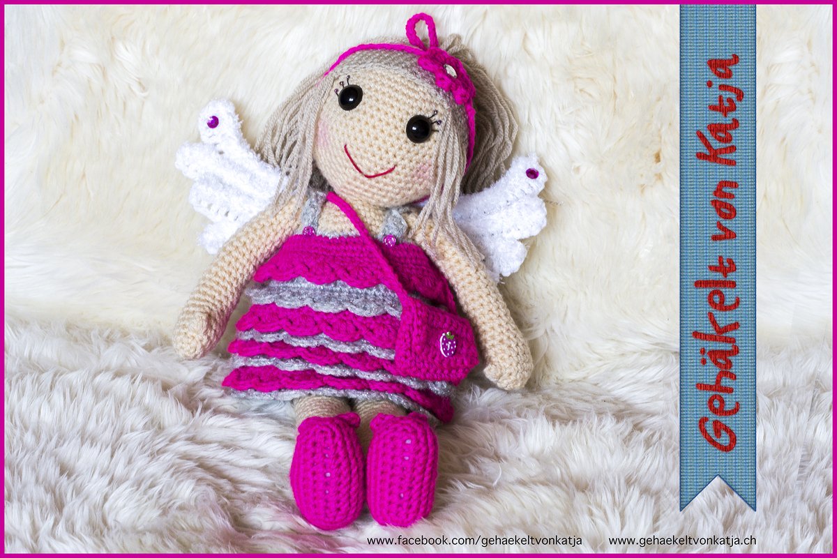 gehäkelte Amigurumi-Puppe Engel mit pink-grauem Rüschenkleid, weißen Flügeln und Tasche