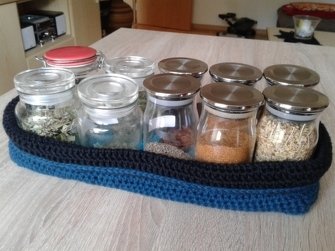 Blaues gehäkeltes Aufbewahrungs-Tablett mit kleinen Glasbehältern