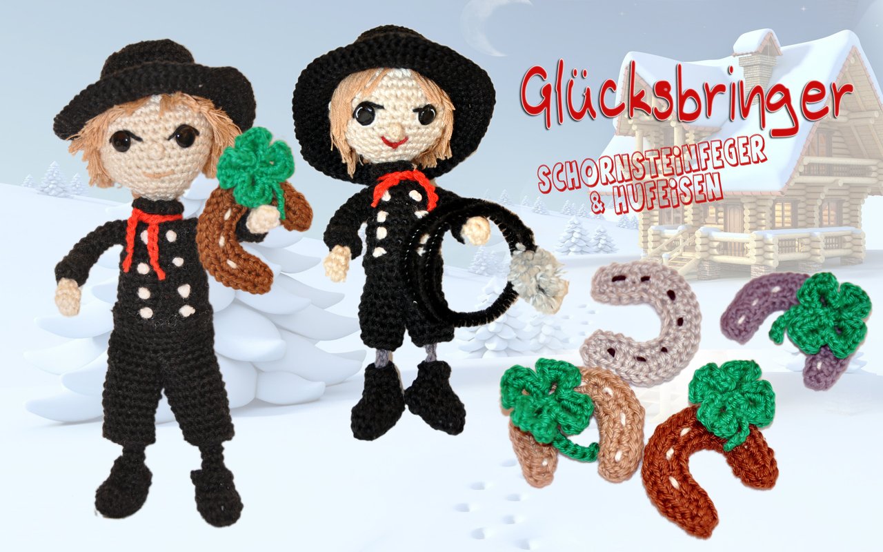 Gehäkelte Amigurumi-Schornsteinfeger mit Hufeisen und Kleeblättern vor winterlicher Landschaft
