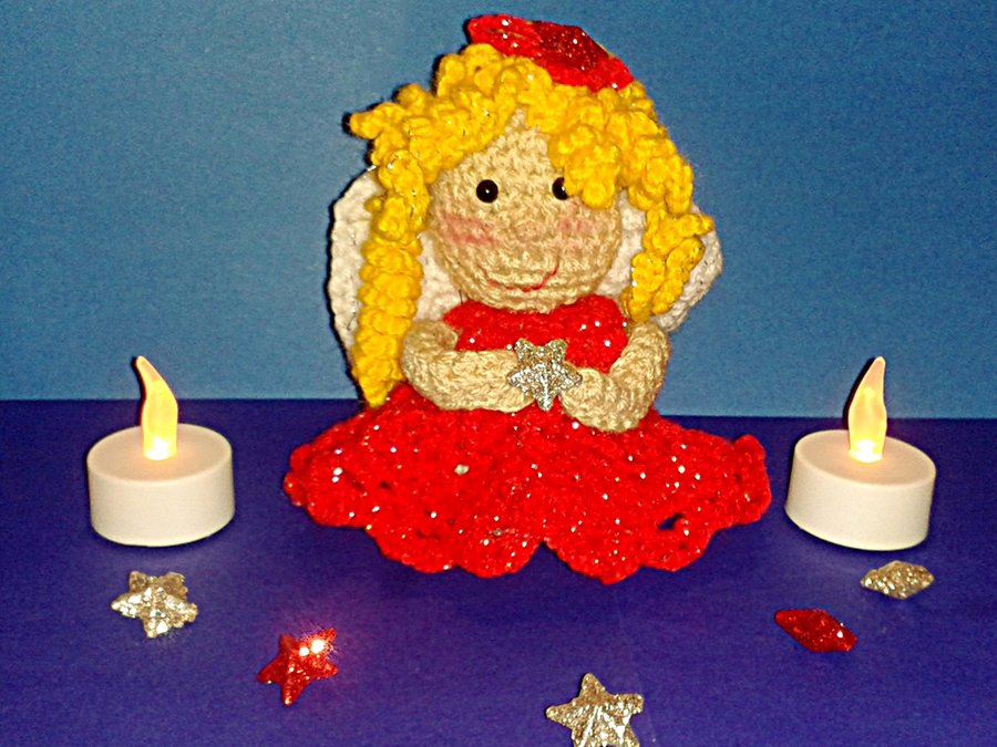 Gehäkeltes Engelchen mit gelben Locken, rotem Kleid und silbernem Stern