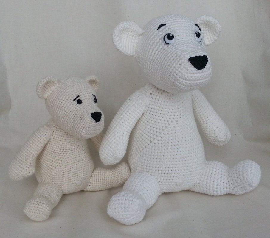 Zwei gehäkelte Eisbären-Amigurumi, einer weiß, einer cremefarben, sitzend mit gestickten Augen und Nasen